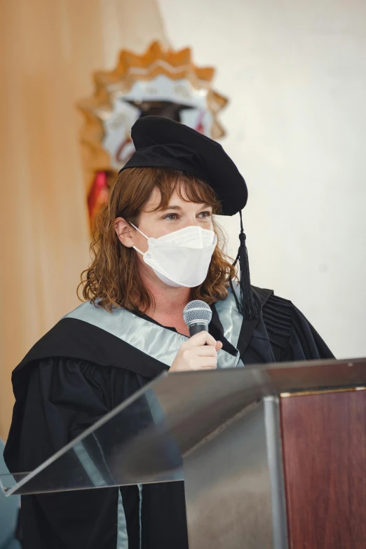 a person at a podium wearing a mask