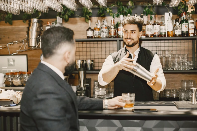 man bartender serves a customer in a modern styled bar