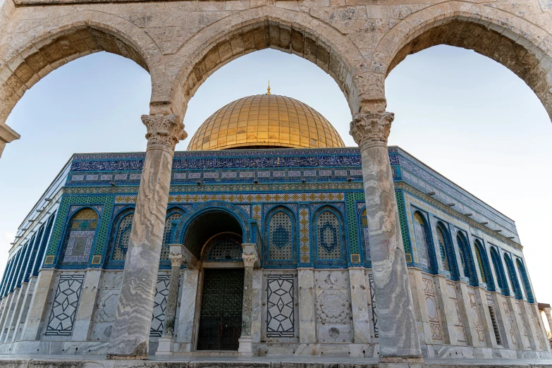 an archway leads to a gold dome with intricate carvings