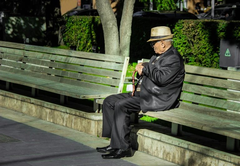 a man sitting on top of a bench next to trees