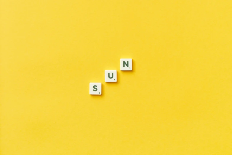 the word nus spelled out with blocks on a yellow background