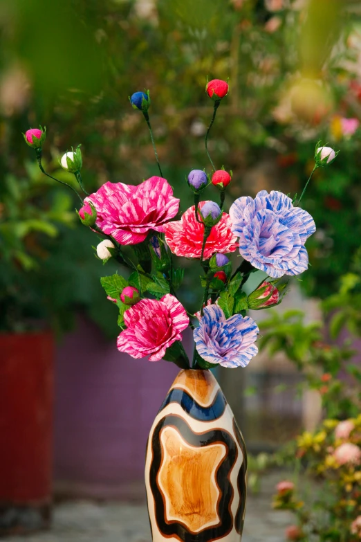 an artful vase of flowers sitting on a table