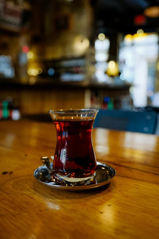 cup with liquid sitting on a table in a bar