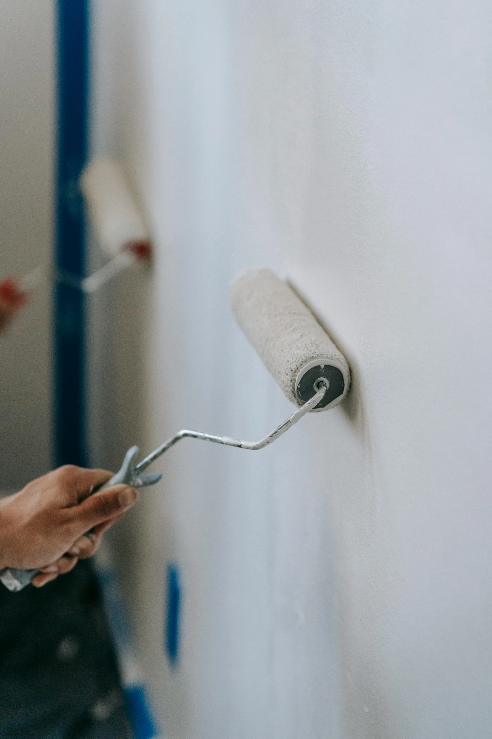 a person using a roller to paint the wall