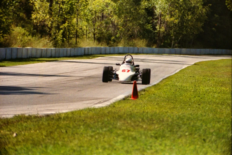 a race car turning around the track with another behind it