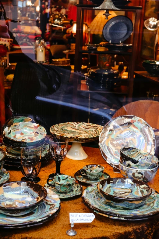 a table full of glass plates and dishes on display