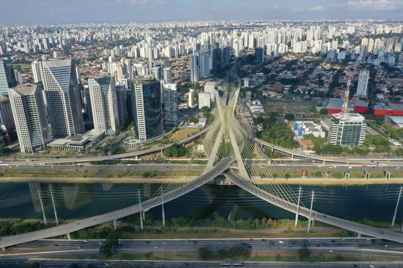 a long bridge crosses over a busy city