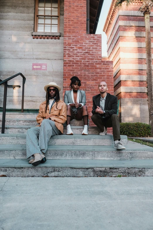 four men sitting down with their feet up on some steps