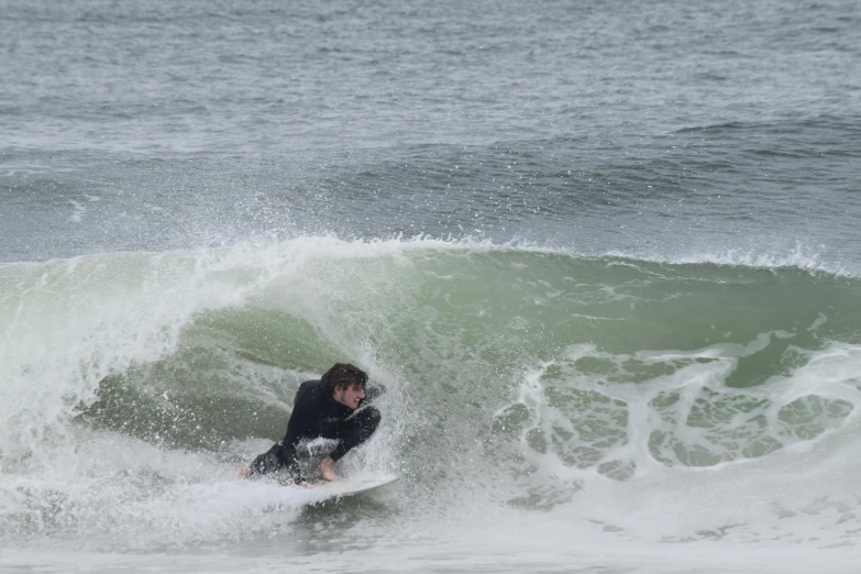 a young man riding a surfboard on a wave