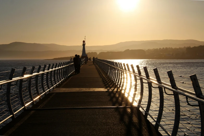 a pier on the shore with a person walking in the water