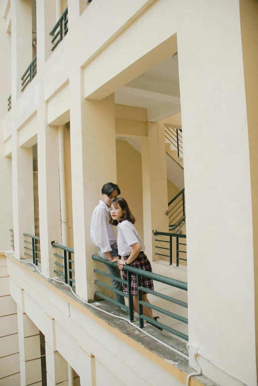 two people standing next to each other near some buildings