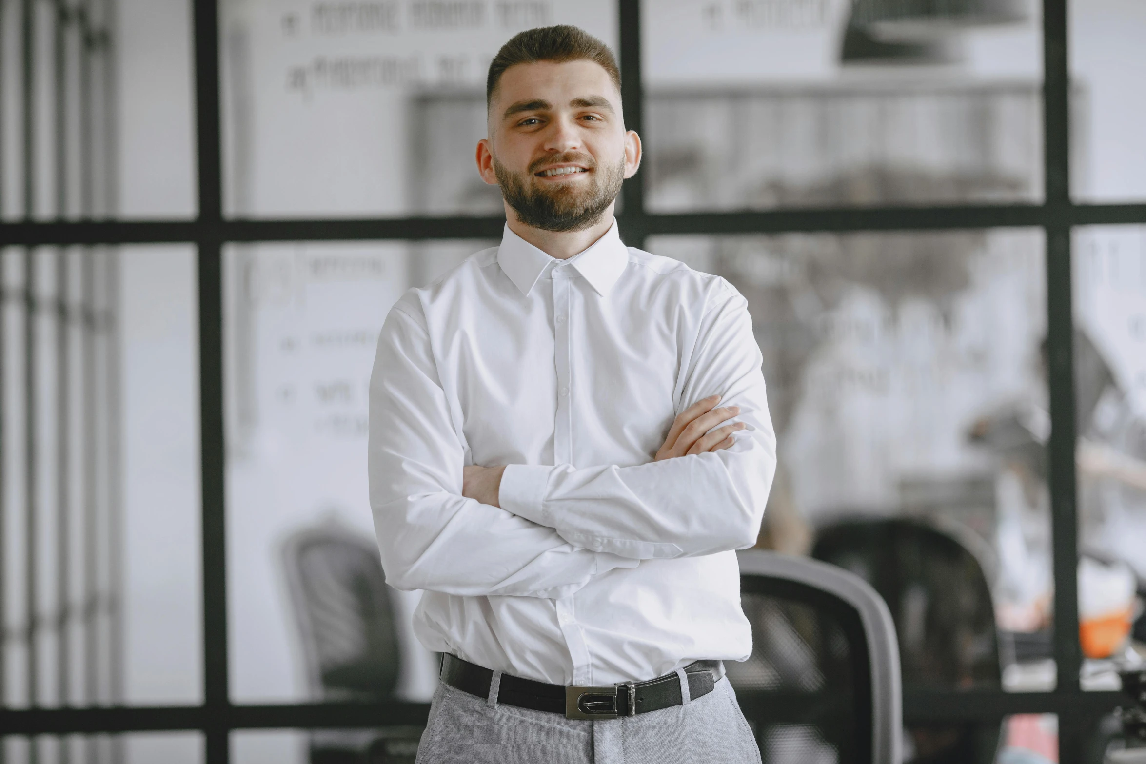 a man in a white shirt is smiling while he stands