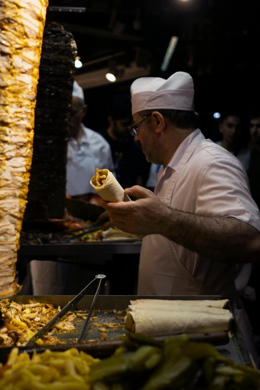 a man is preparing a sandwich in his home kitchen