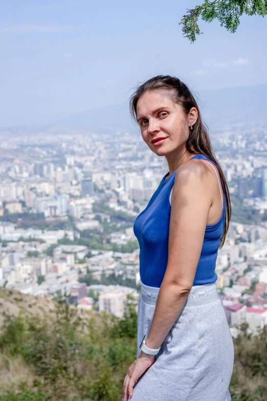 a woman wearing a blue shirt and silver dress