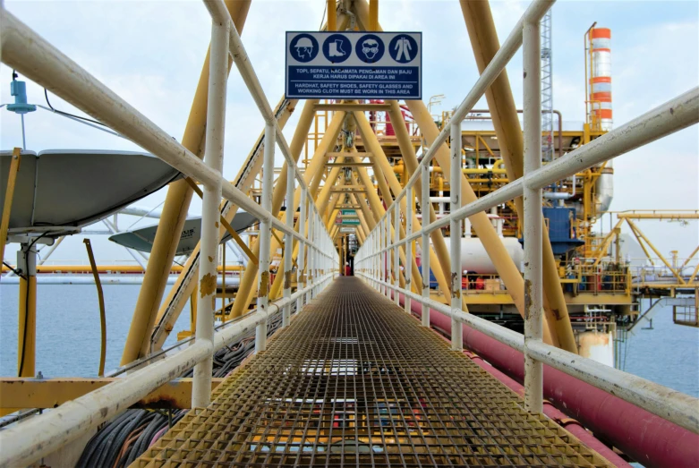 yellow lines on the side of a bridge with large pipes on it