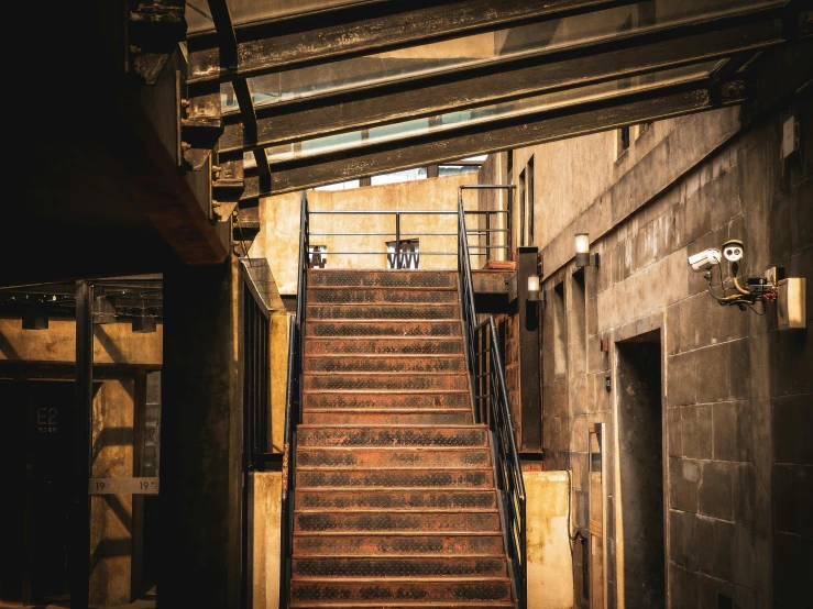 a stair case in an industrial area with a concrete building on either side