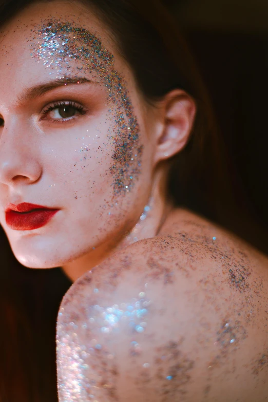 a woman with silver glitters is posing for the camera