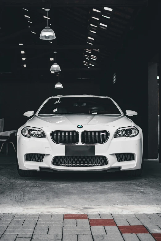 the front view of a white car parked in a garage