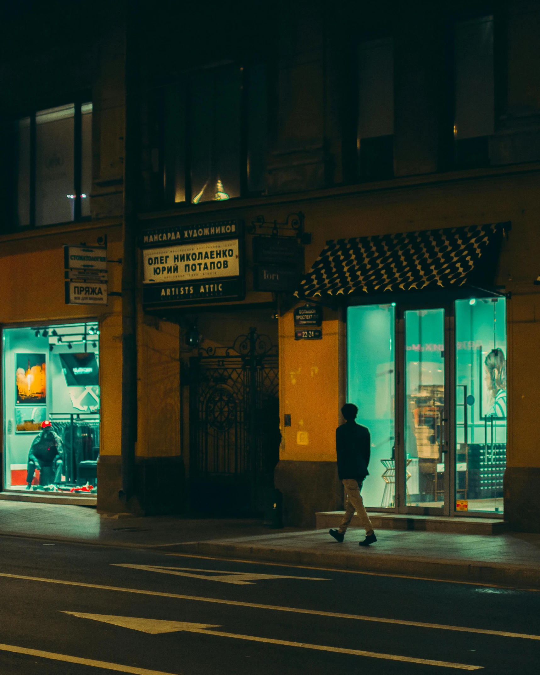 a man walking on the side walk at night