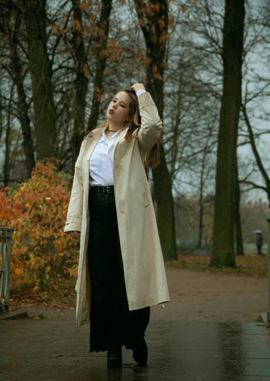 a woman is walking on the sidewalk in the rain