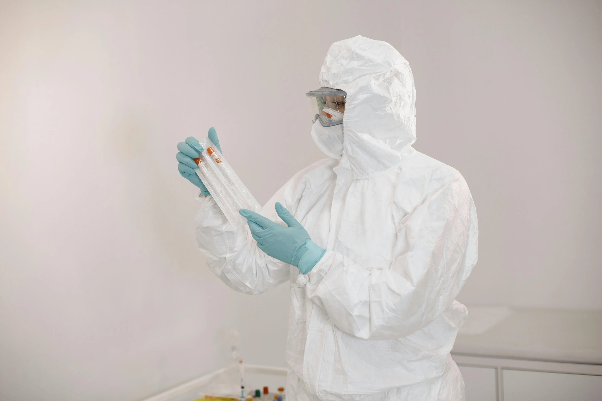 a person in white clothing and blue gloves