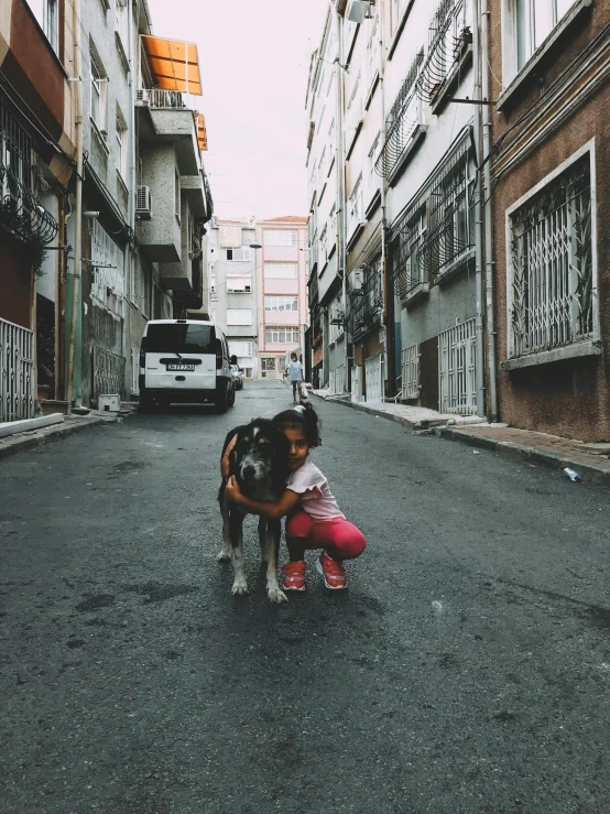 a  hugging a puppy on the street