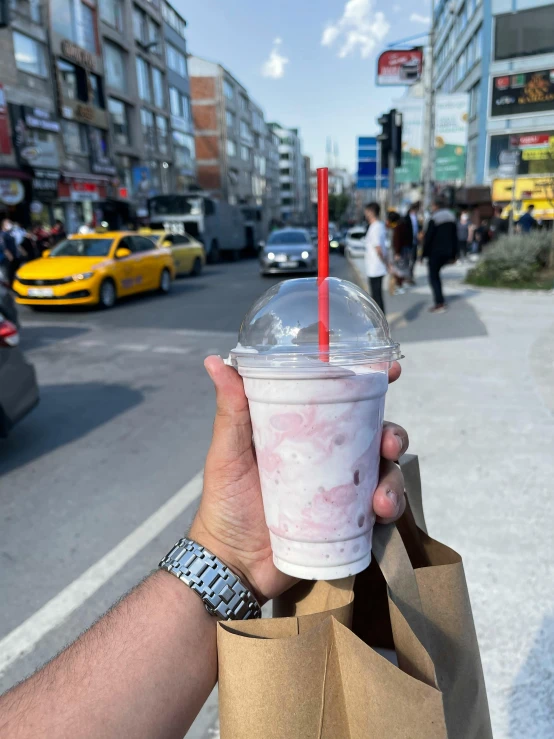 a man holding a cup with red liquid in it