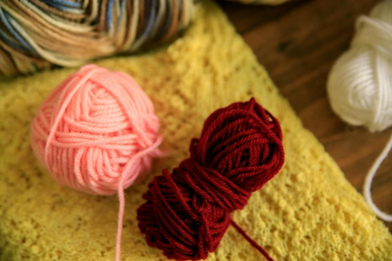 two skeins of yarn are laying on top of a knitting mat