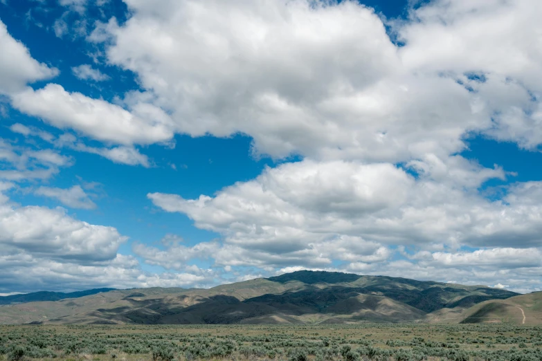 a mountain range is shown under clouds in the sky