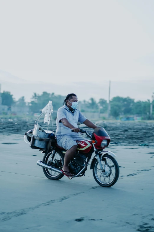 a man on a motorcycle riding through a barren area