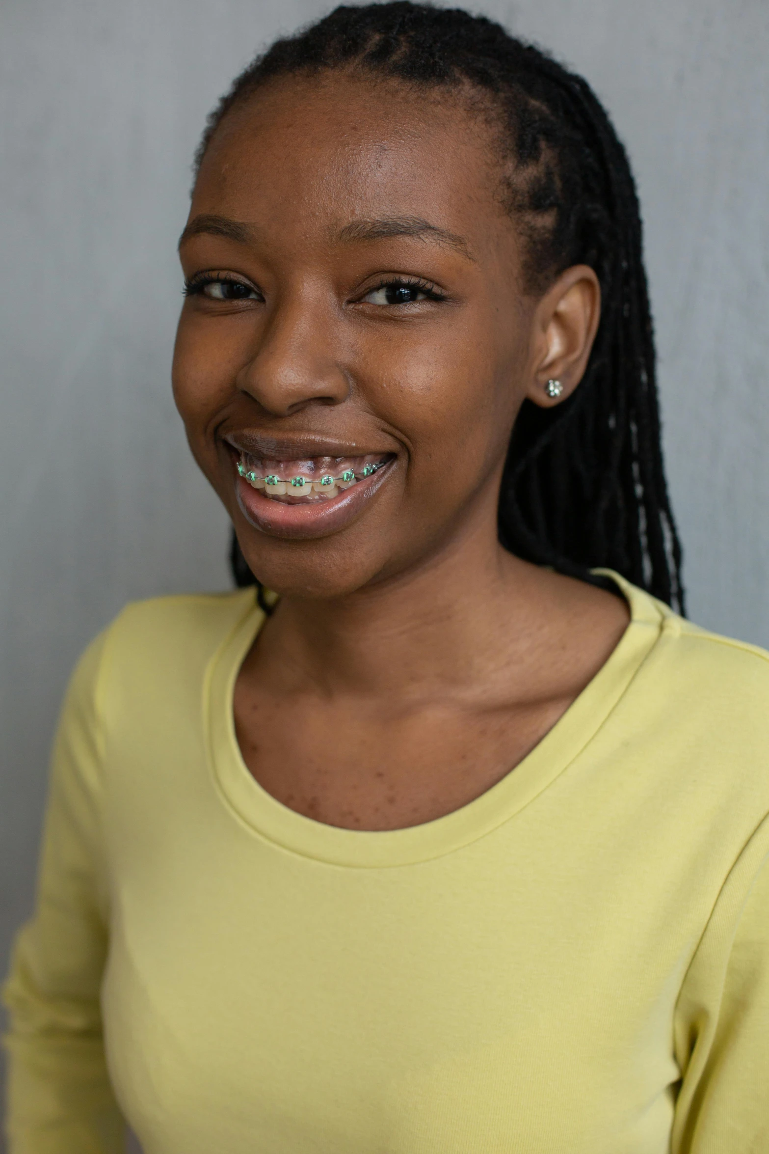 a smiling woman with ces and a toothbrush in her mouth