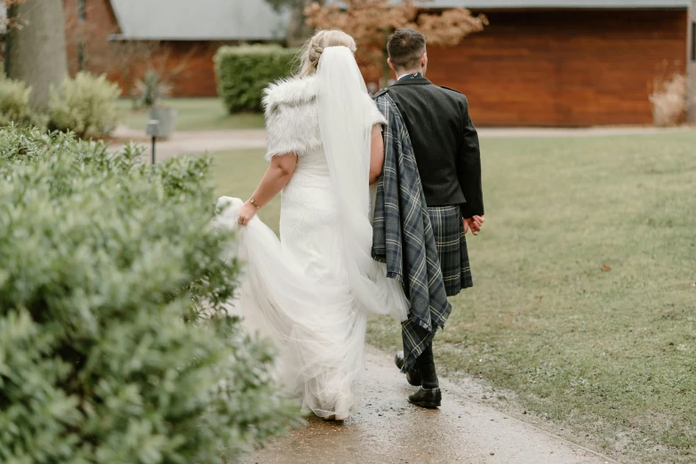 a bride and groom walking down a path at their wedding