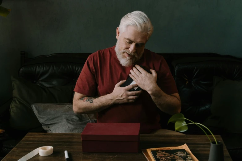 a man in red shirt sitting at a table