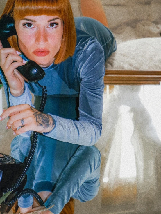 a woman sits on a stool and talks on the phone