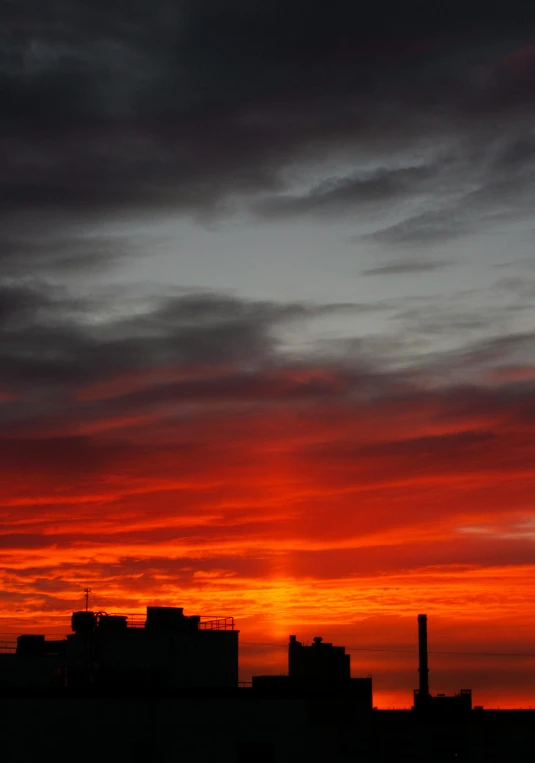 a cloudy sunset over an apartment building in the city