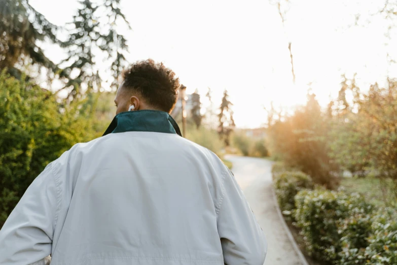 a man walking down a narrow street at dusk