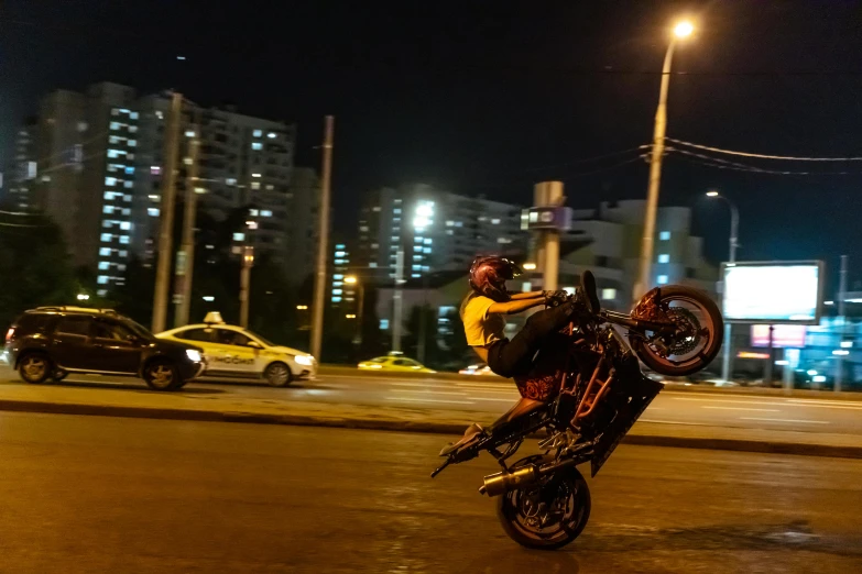 a guy riding a motorcycle on the side of a street