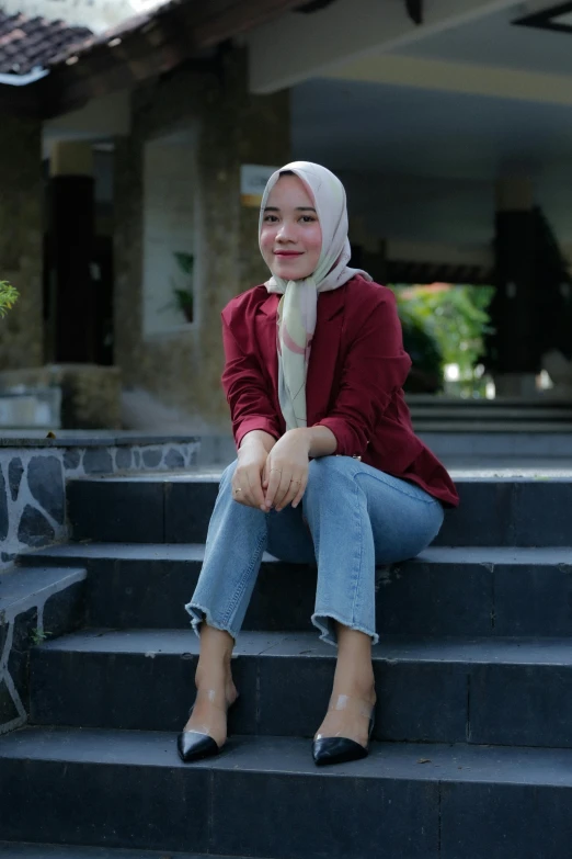 a woman is sitting on the stairs of a house