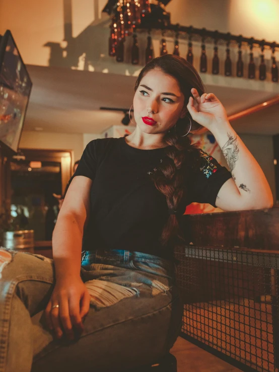 woman with colorful nails sitting on bench with her hair in half up