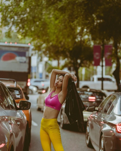 a woman in yellow pants standing next to a car