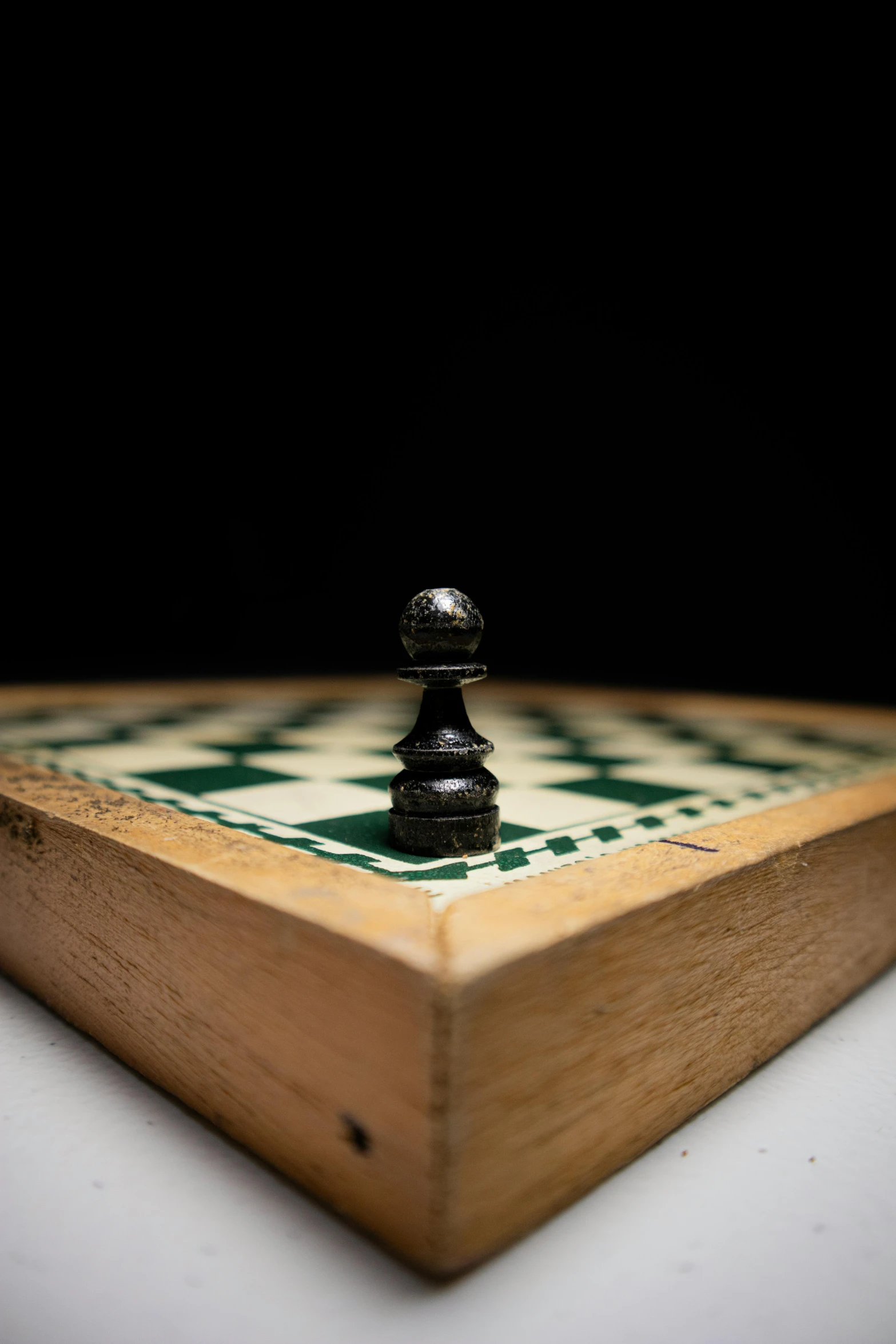 a black and green chess piece on a board