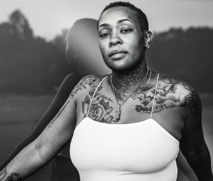 a tattooed woman poses for the camera in black and white