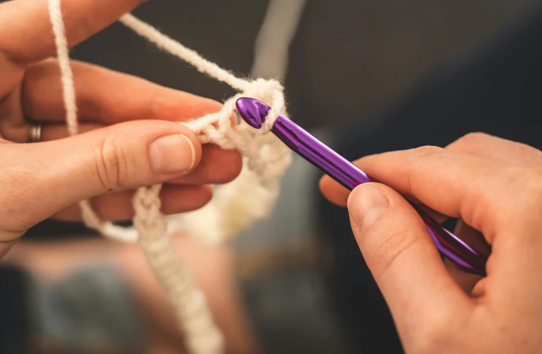 the two hands of the person are holding a piece of string