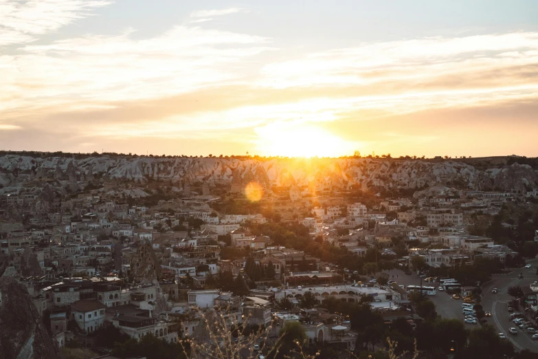 sunset over a city with tall buildings and trees