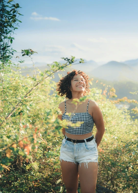  posing in plaid top and denim shorts