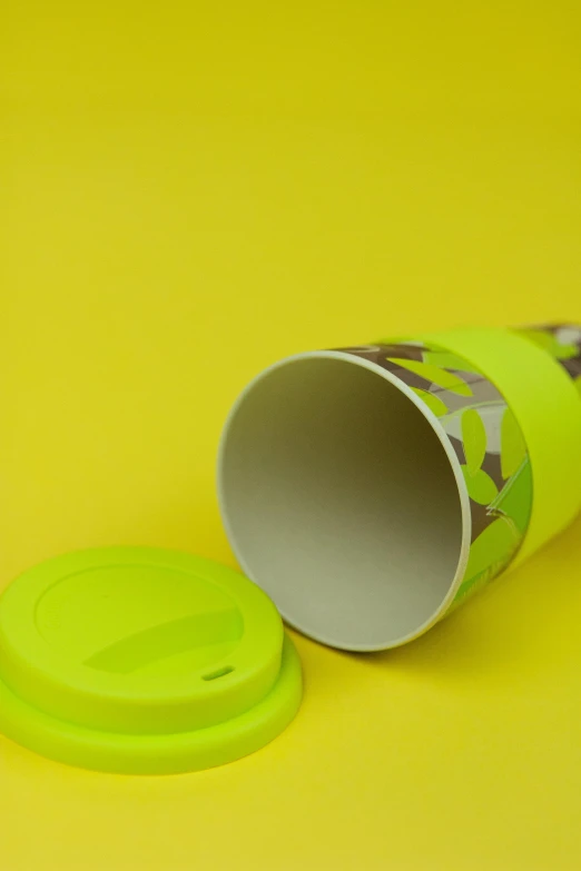 a yellow cup with a plastic lid sitting on a table