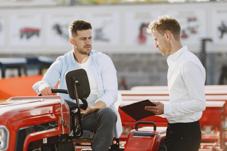 two men sitting down to discuss soing on a tractor