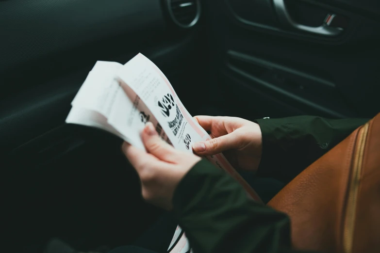 someone is holding out a piece of paper to their passenger