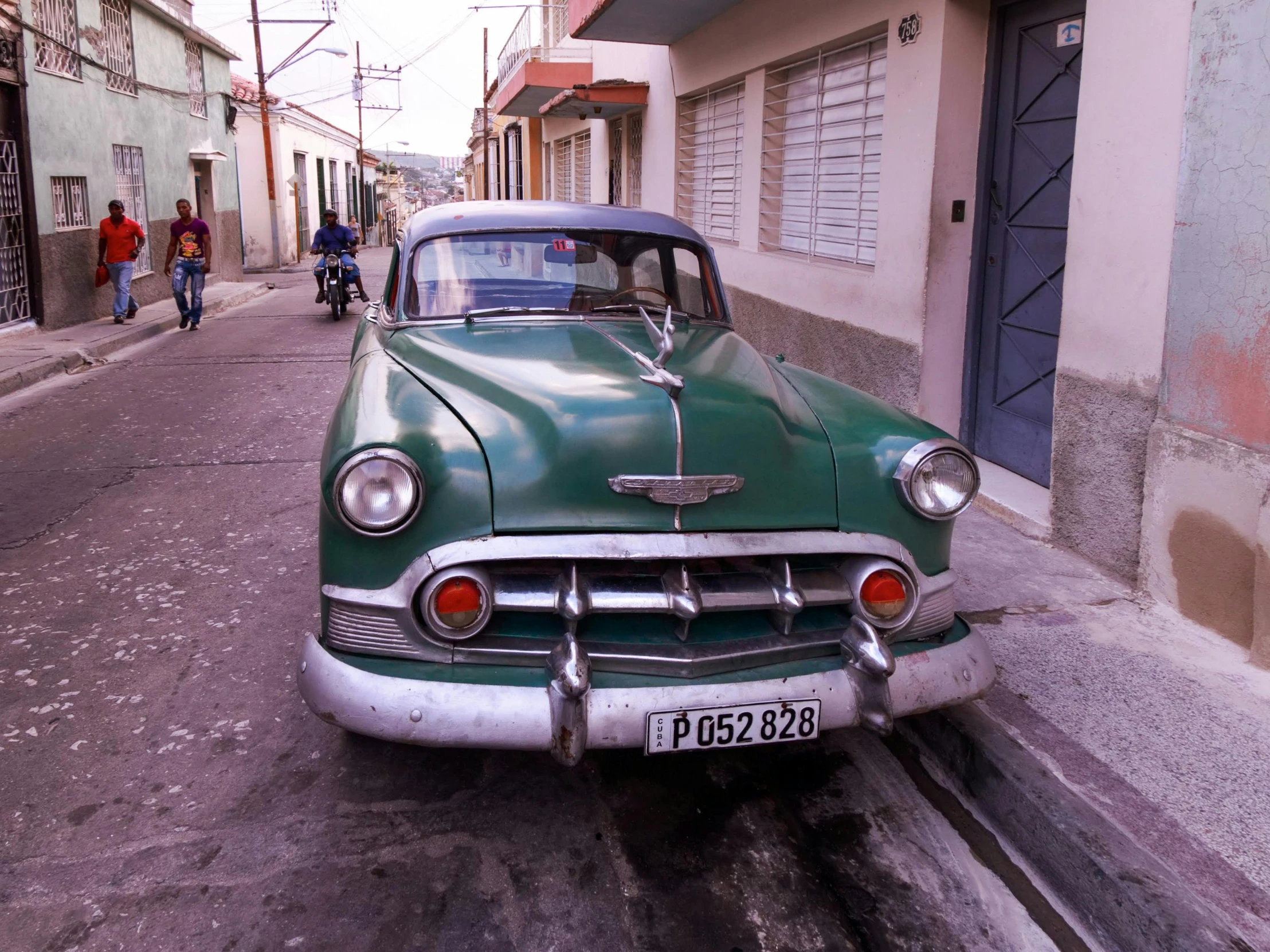 an old green truck parked on the side of the road