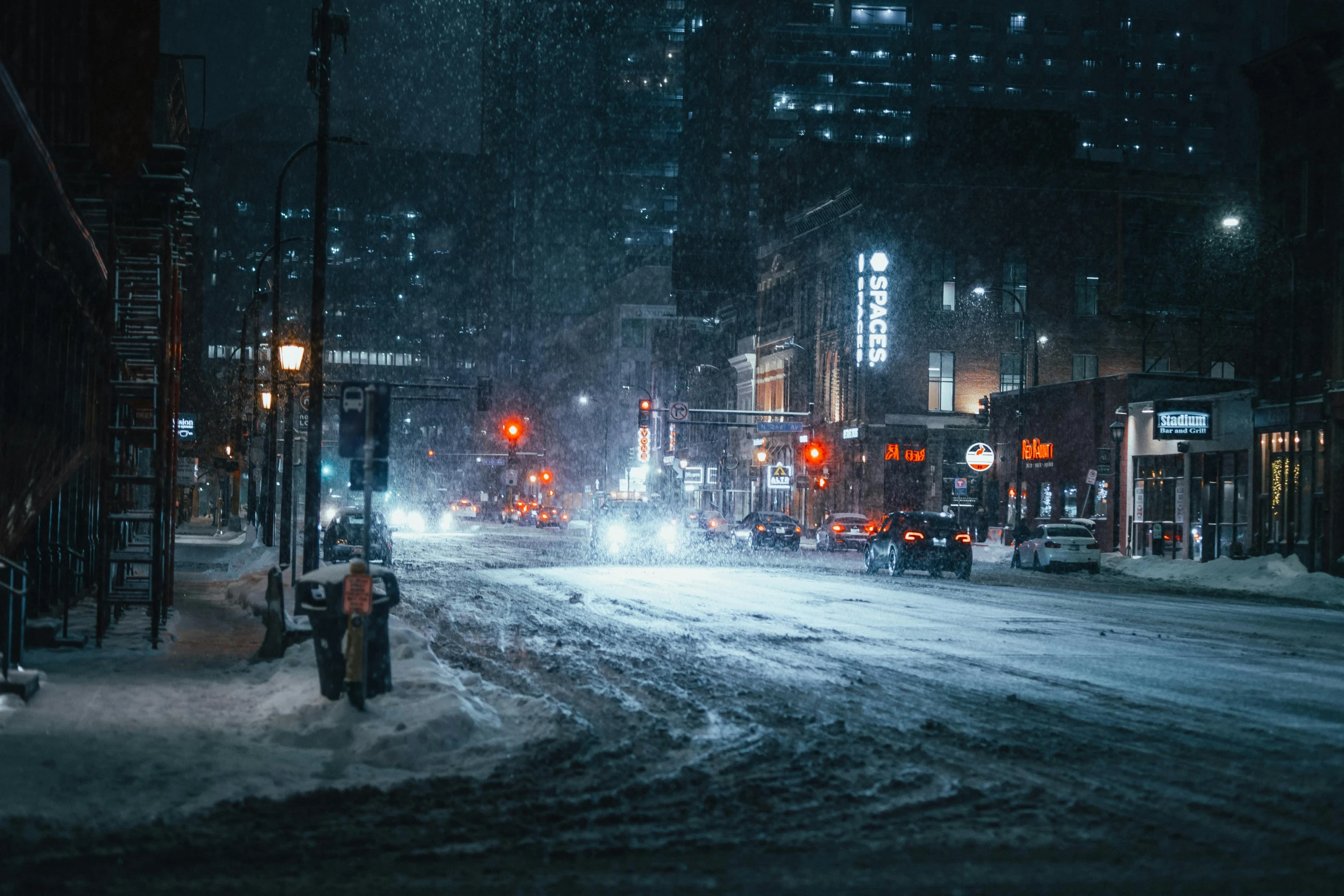 people crossing the street in the snow at night